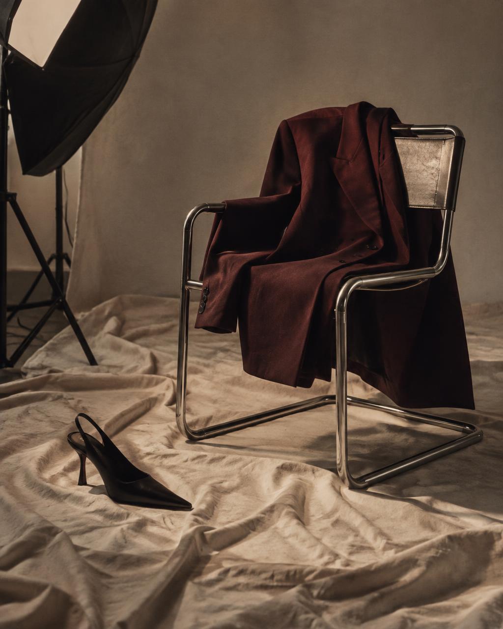 Bordeauxfarbener Blazer auf einem Chromstuhl im Fotostudio